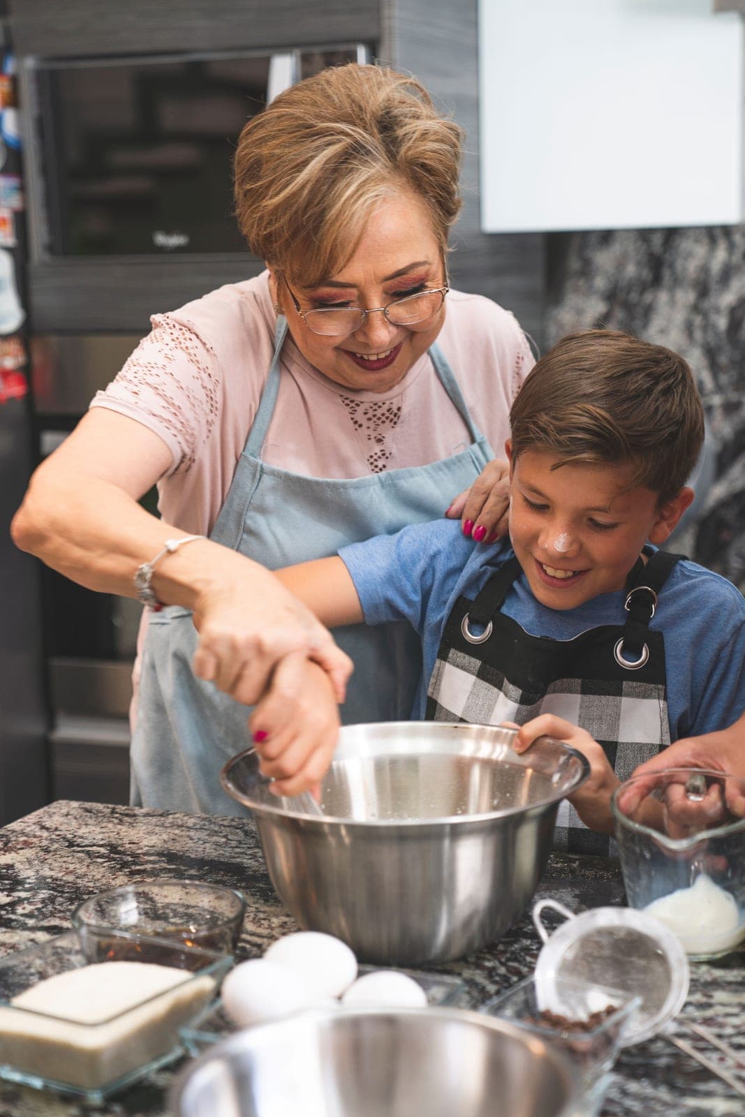 Baker at Little Oven Bakery mixing batter with a young helper