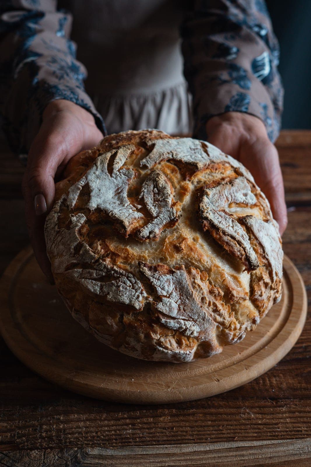Fresh baked sourdough loaf held in hands